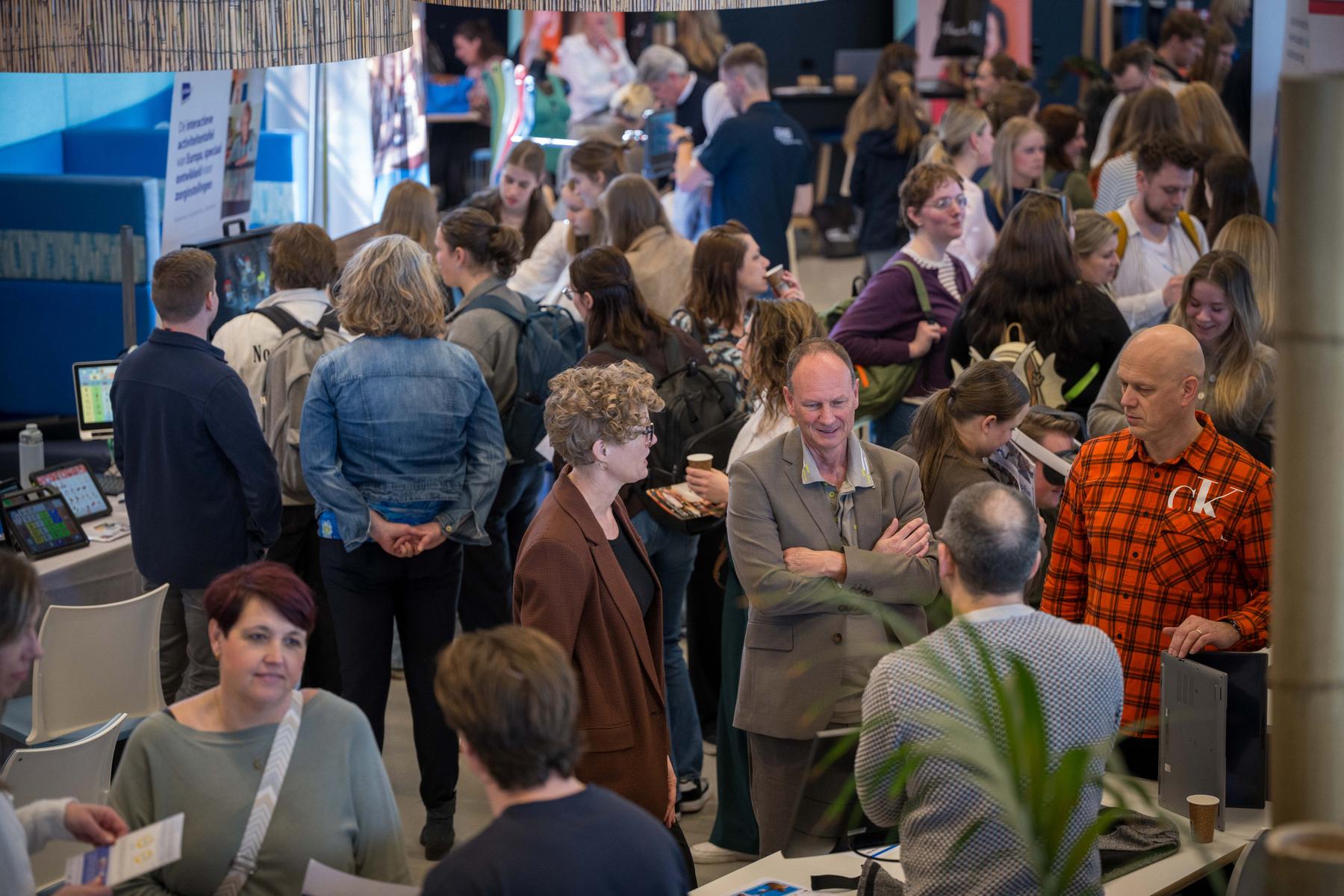 Drukke beursvloer tijdens de Technology Experience Day 2026 met bezoekers bij stands met zorgtechnologie